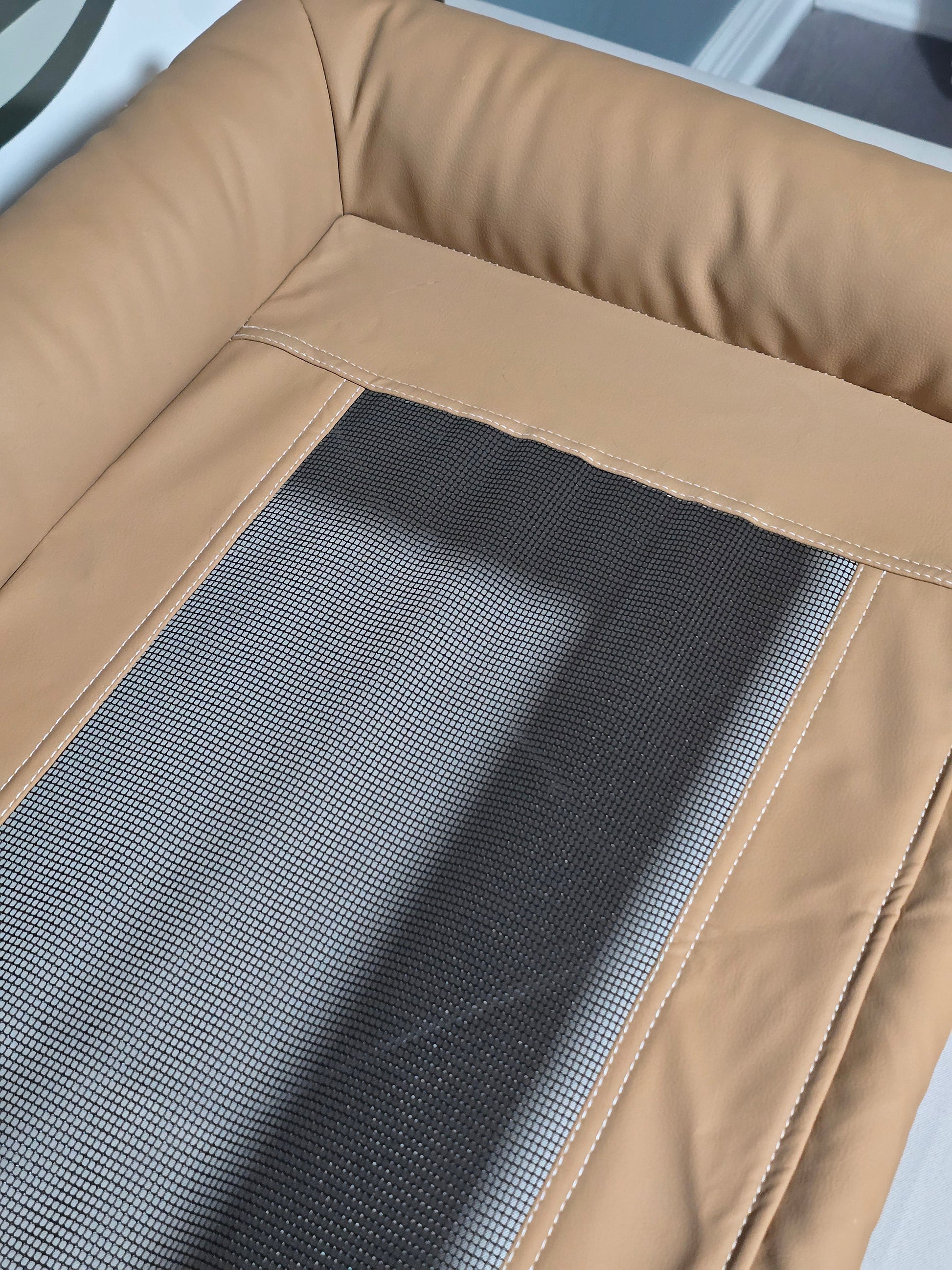Top-down detail of the breathable mesh sleeping surface with contrast stitching
