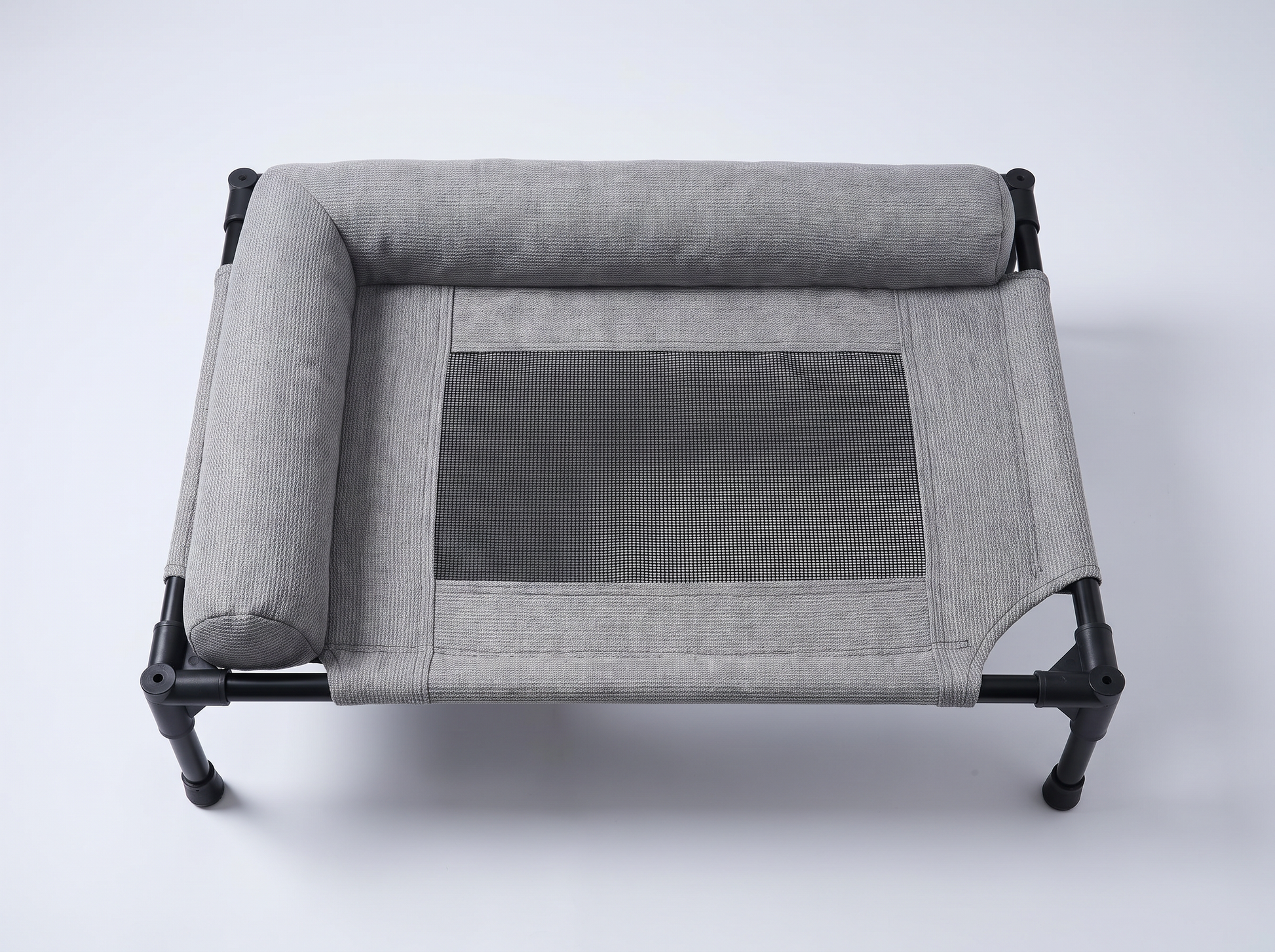 Top view of the grey Breeze Cot — L-shaped bolster and mesh centre